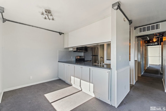 kitchen featuring sink, dark colored carpet, white cabinetry, appliances with stainless steel finishes, and backsplash