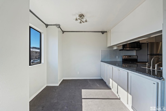 kitchen featuring tasteful backsplash, white cabinetry, sink, dark colored carpet, and stainless steel appliances