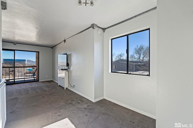 unfurnished room featuring dark carpet