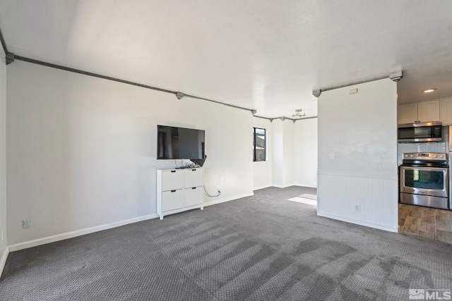 unfurnished living room featuring dark colored carpet