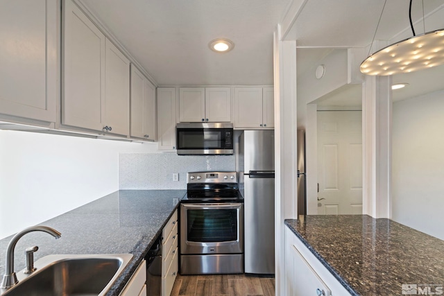 kitchen with white cabinetry, sink, hanging light fixtures, and appliances with stainless steel finishes