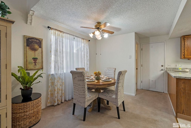 carpeted dining space featuring ceiling fan and a textured ceiling