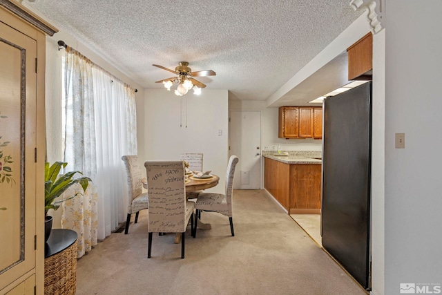 carpeted dining room with ceiling fan and a textured ceiling