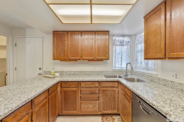 kitchen with light stone countertops, black dishwasher, and sink