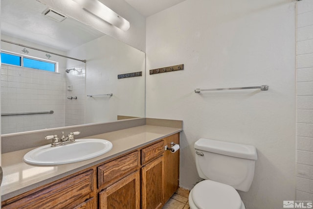 bathroom with vanity, toilet, and tiled shower