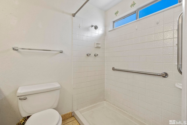 bathroom with tiled shower and toilet