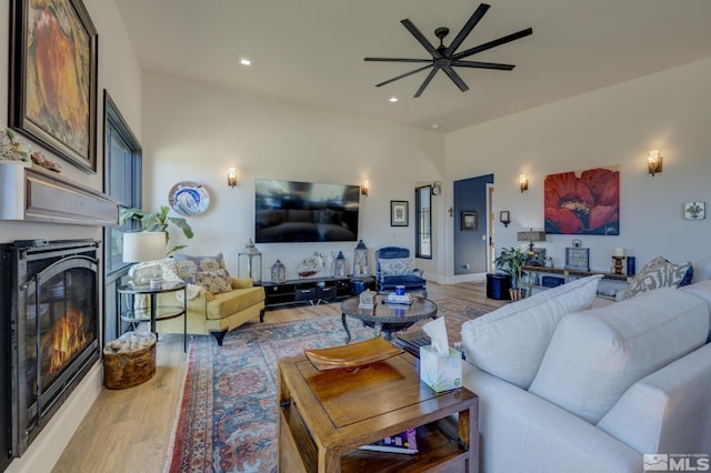 living room with wood-type flooring and ceiling fan