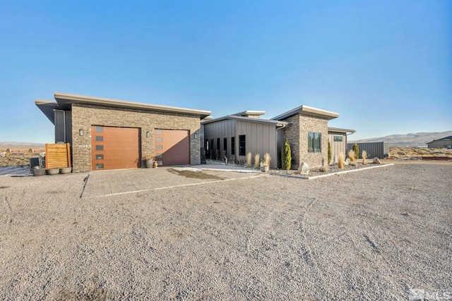 back of house featuring a garage and a mountain view