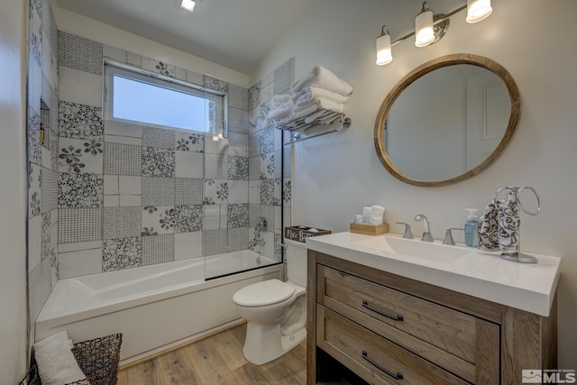 full bathroom featuring tiled shower / bath, wood-type flooring, toilet, and vanity