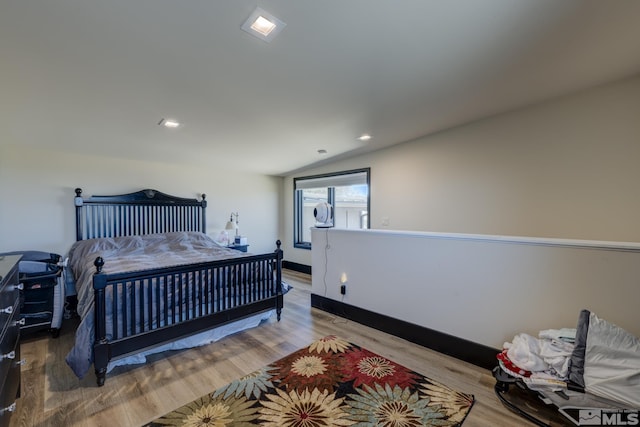 bedroom with hardwood / wood-style flooring and vaulted ceiling