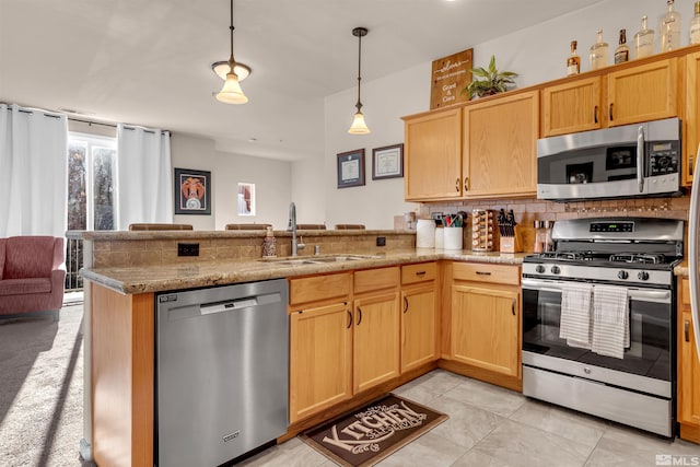 kitchen with sink, hanging light fixtures, stainless steel appliances, and kitchen peninsula