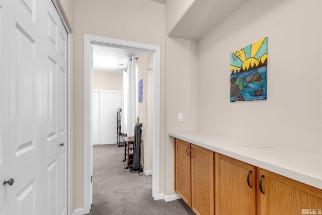 hall with dark colored carpet