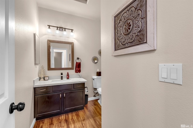 bathroom with vanity, wood-type flooring, and toilet