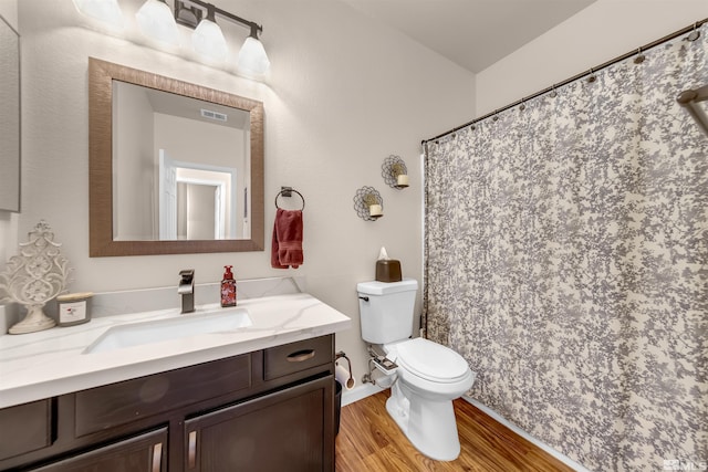 bathroom with hardwood / wood-style flooring, vanity, and toilet