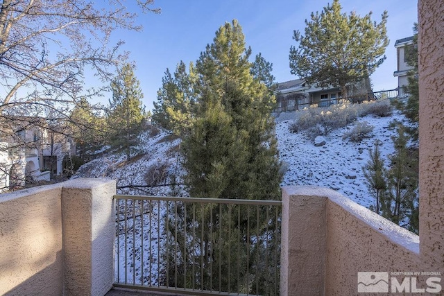 view of snow covered back of property