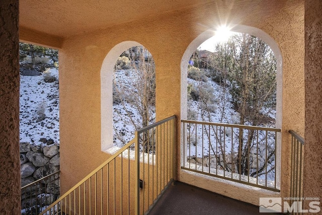 view of snow covered back of property