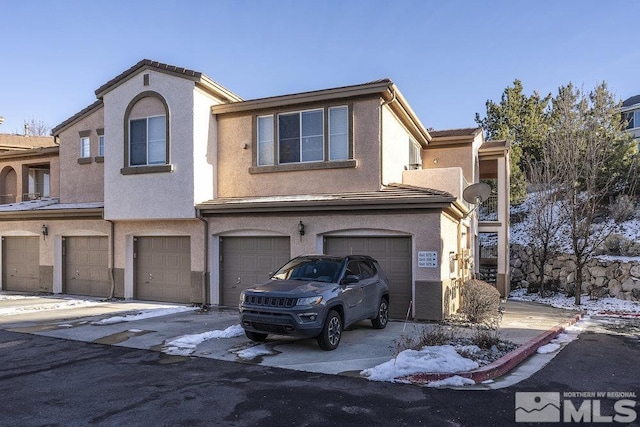 view of front of house featuring a garage, driveway, and stucco siding