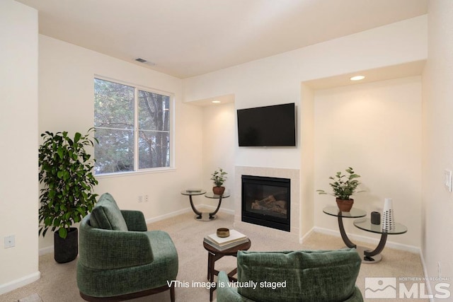 carpeted living area featuring visible vents, a fireplace, and baseboards