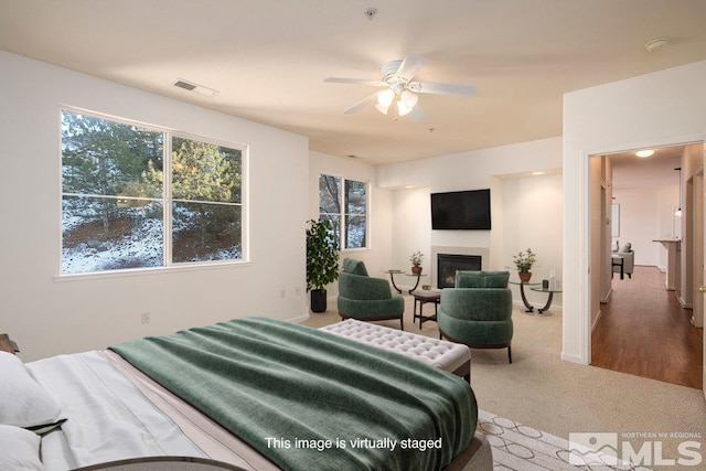 bedroom featuring visible vents, baseboards, carpet flooring, and a fireplace