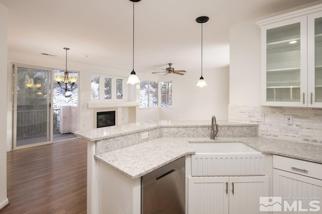 kitchen with sink, white cabinetry, hanging light fixtures, light stone counters, and stainless steel dishwasher