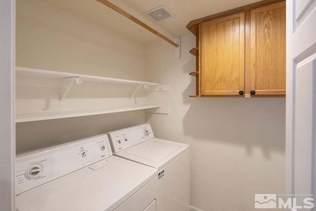 laundry area with washing machine and clothes dryer, visible vents, and cabinet space