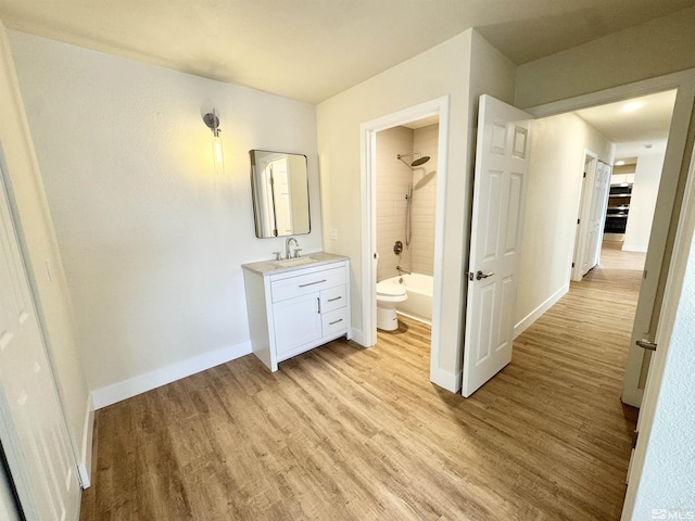 full bathroom featuring vanity, toilet, tiled shower / bath combo, and hardwood / wood-style floors