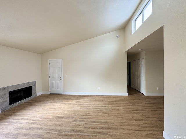 unfurnished living room with high vaulted ceiling and light hardwood / wood-style flooring