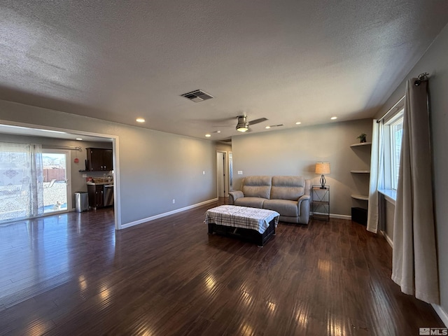 living room with plenty of natural light, dark hardwood / wood-style floors, and a textured ceiling