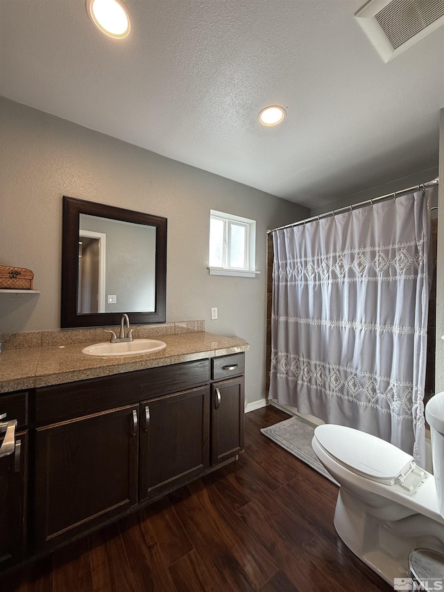 bathroom with toilet, wood-type flooring, a textured ceiling, vanity, and a shower with shower curtain