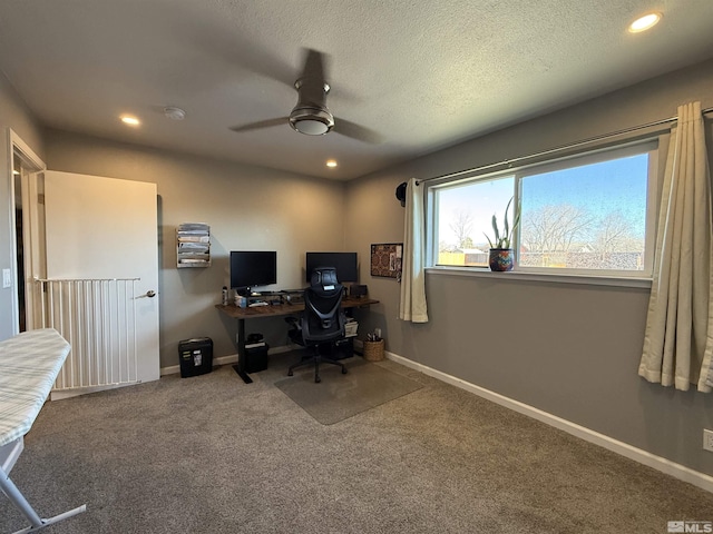 carpeted office space featuring ceiling fan and a textured ceiling