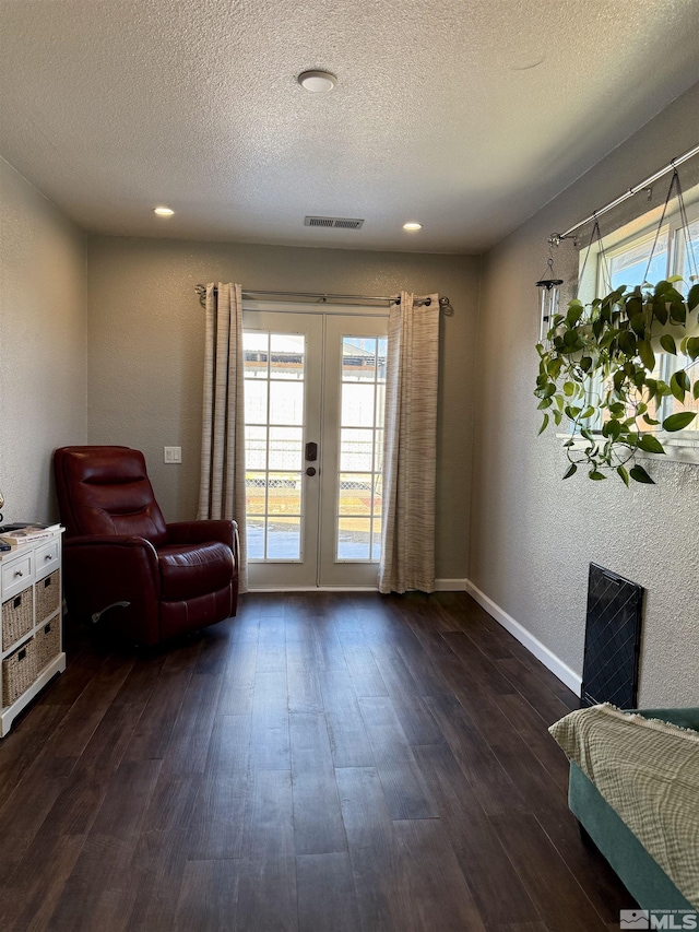 sitting room with french doors, dark wood-type flooring, and a textured ceiling