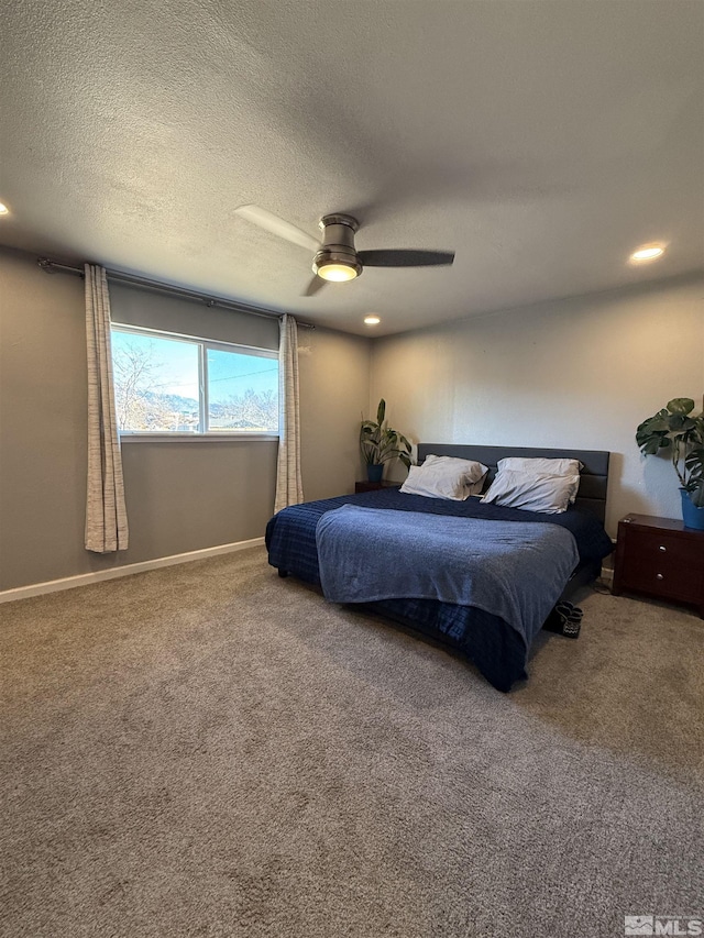 bedroom featuring ceiling fan, carpet floors, and a textured ceiling