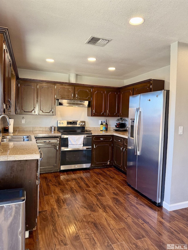 kitchen featuring appliances with stainless steel finishes, sink, dark brown cabinetry, dark wood-type flooring, and a textured ceiling