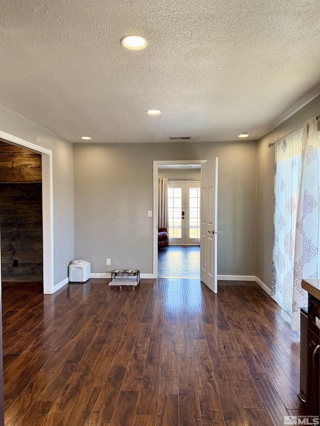 unfurnished room with dark hardwood / wood-style flooring, french doors, and a textured ceiling