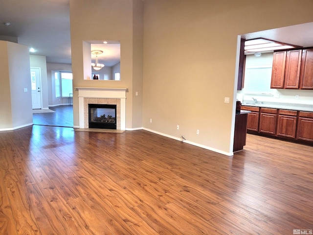 unfurnished living room featuring hardwood / wood-style flooring and a tile fireplace