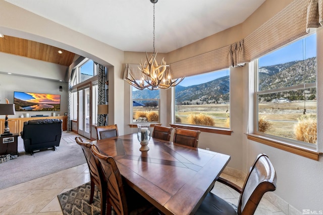 dining room featuring a mountain view, light tile patterned floors, and a chandelier