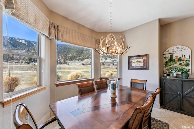 dining area with a mountain view, a notable chandelier, and light tile patterned floors