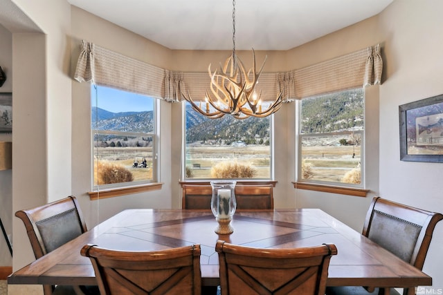 dining room featuring a mountain view and a notable chandelier