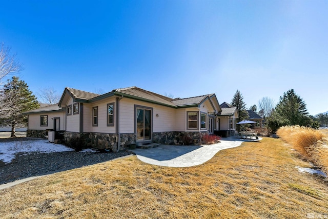 view of side of property with a patio and a yard