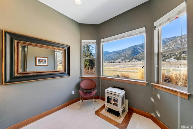 living area featuring carpet flooring, a mountain view, and a wood stove