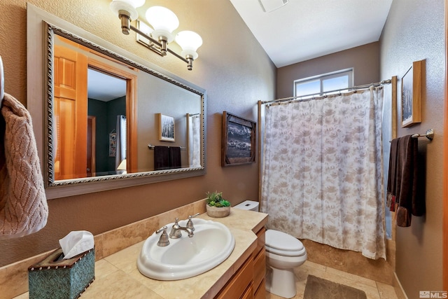 bathroom featuring vanity, walk in shower, and toilet