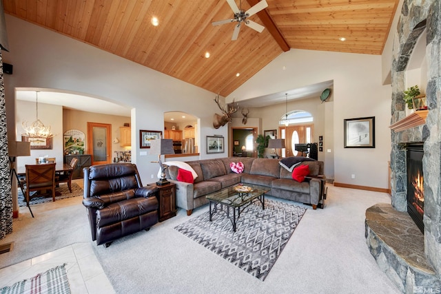 living room with wood ceiling, light colored carpet, a stone fireplace, and high vaulted ceiling