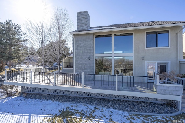 snow covered rear of property featuring a wooden deck