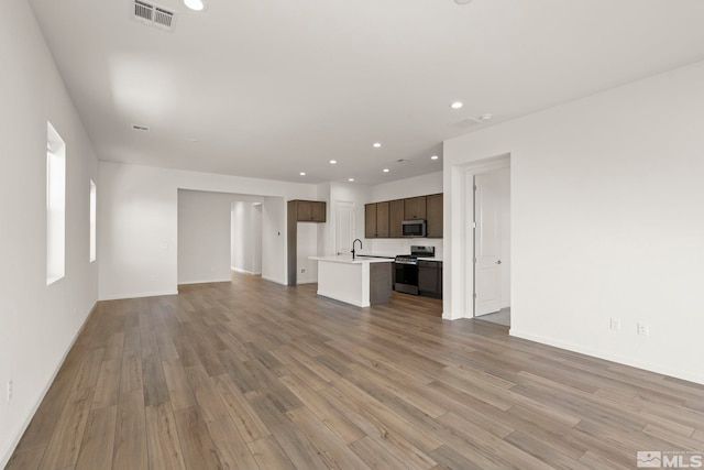 unfurnished living room with sink and light hardwood / wood-style flooring