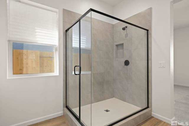 bathroom featuring a shower with door and hardwood / wood-style floors