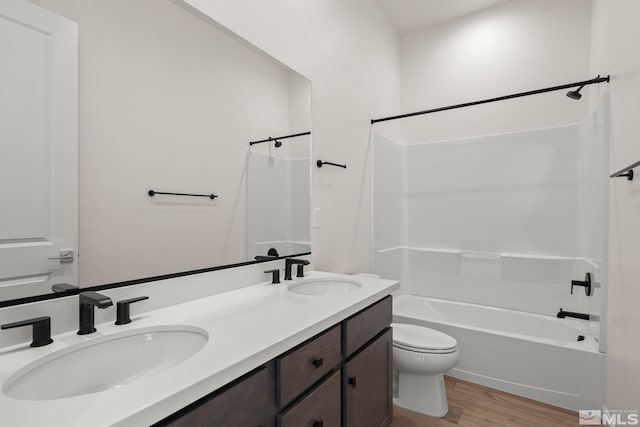 full bathroom featuring wood-type flooring, toilet, shower / bathing tub combination, and vanity