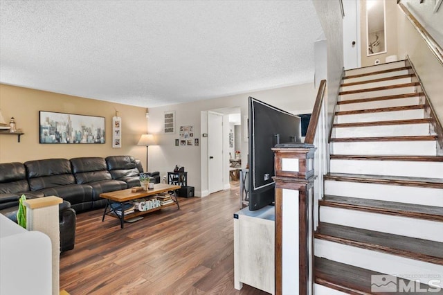 living room with dark wood-type flooring and a textured ceiling