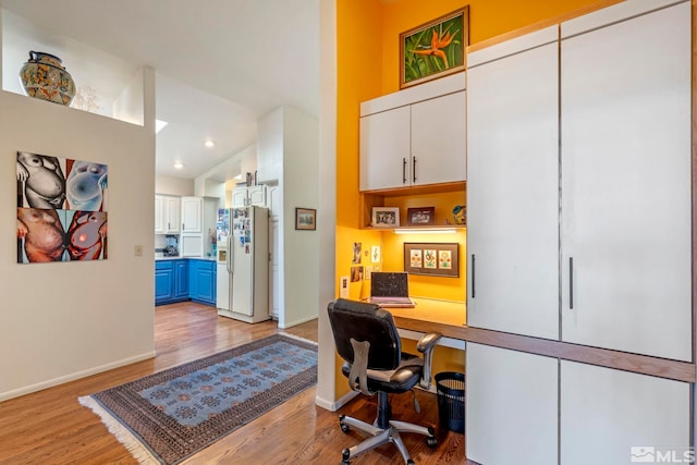 office space featuring built in desk and light wood-type flooring