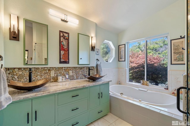 bathroom with independent shower and bath, vanity, and vaulted ceiling