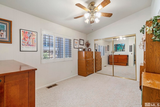 carpeted bedroom with lofted ceiling, ceiling fan, and a closet